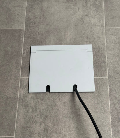 Double Matt White Recessed Floor Socket With Lid Closed Flat Showing Just Cable Coming Out If The Socket - Side On View.