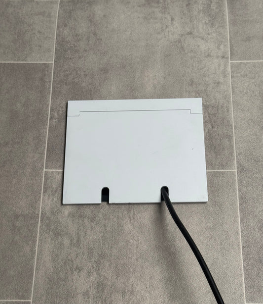 Double Matt White Recessed Floor Socket With Lid Closed Flat Showing Just Cable Coming Out If The Socket - Side On View.