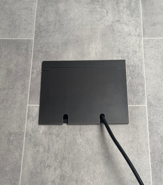 Double Old Bronzes Recessed Floor Socket With Lid Closed Flat Showing Just Cable Coming Out If The Socket - Front On View.