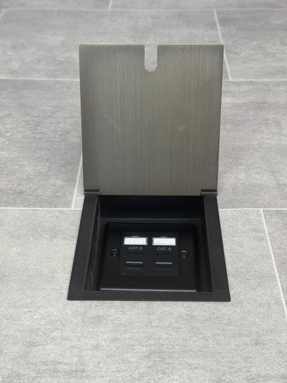 A recessed floor socket with an antique brass cover, two RJ45 sockets, designed for network cable management.