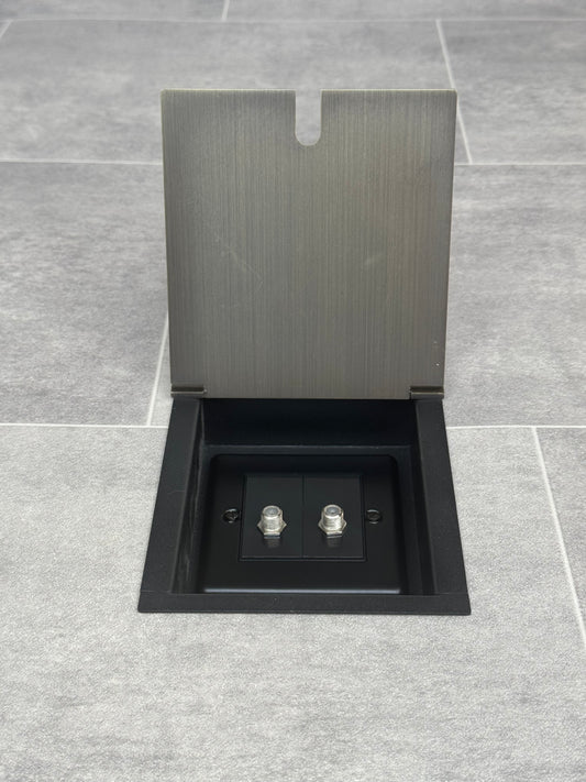 A antique brass recessed floor socket with two satellite F connectors for dual satellite feed.
