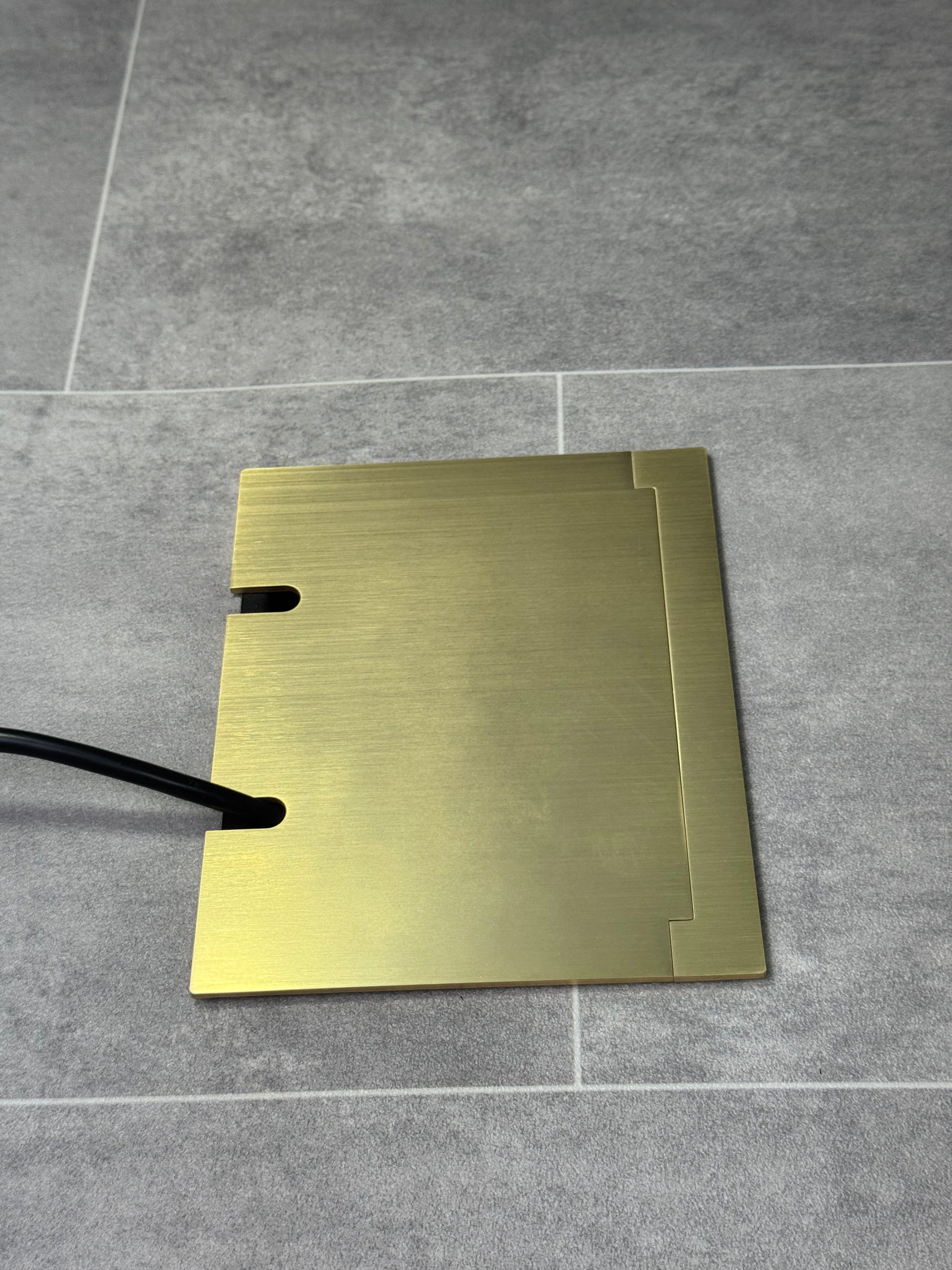 Double Satin Brass Recessed Floor Socket With Lid Closed Flat Showing Just Cable Coming Out If The Socket - Side On View.