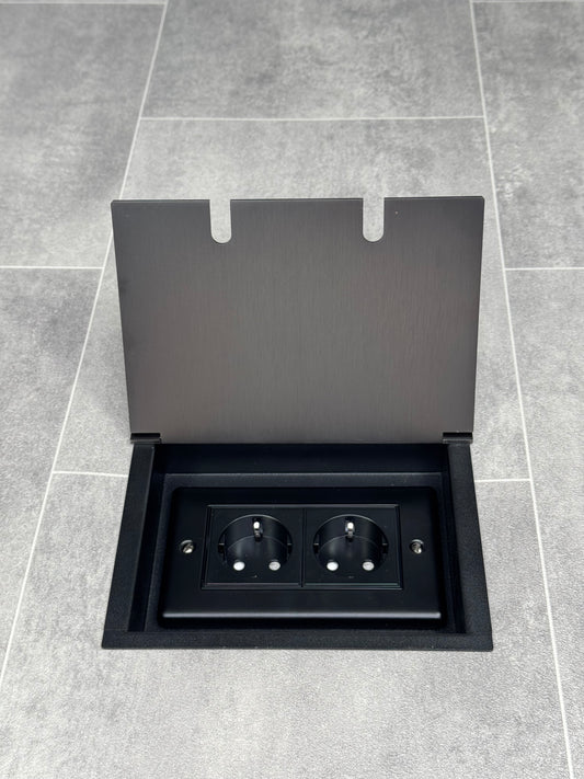 Old bronze double recessed floor  featuring a double gang design with two Schuko outlets, set into a grey tiled floor.