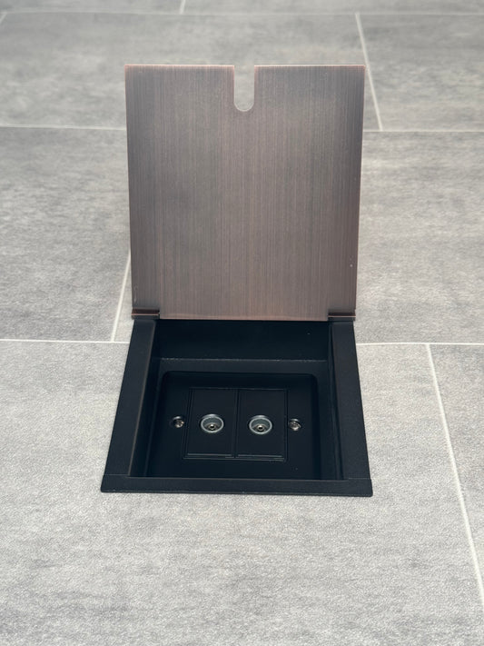 A 2 gang TV socket in a antique copper recessed floor socket.