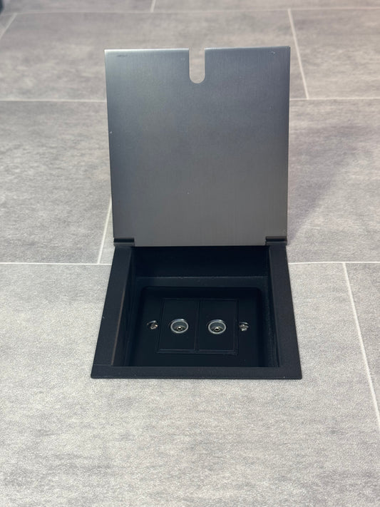Old bronze recessed floor socket with a 2 gang TV socket, shown in an open position with the surrounding floor visible.