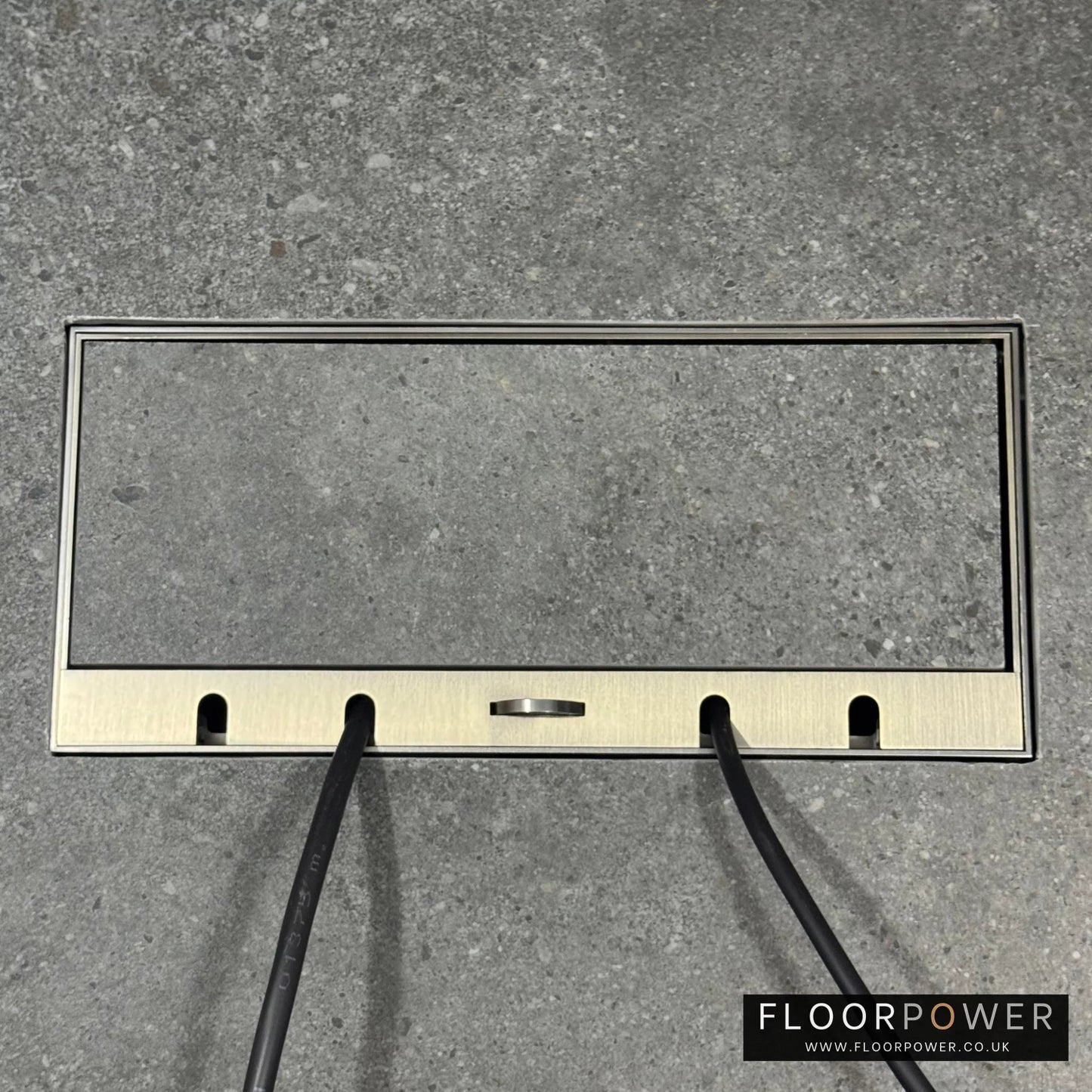 Flush Recessed Floor Socket with Antique Brass Surround in grey stone floor showing closed lid and 2 wires coming out