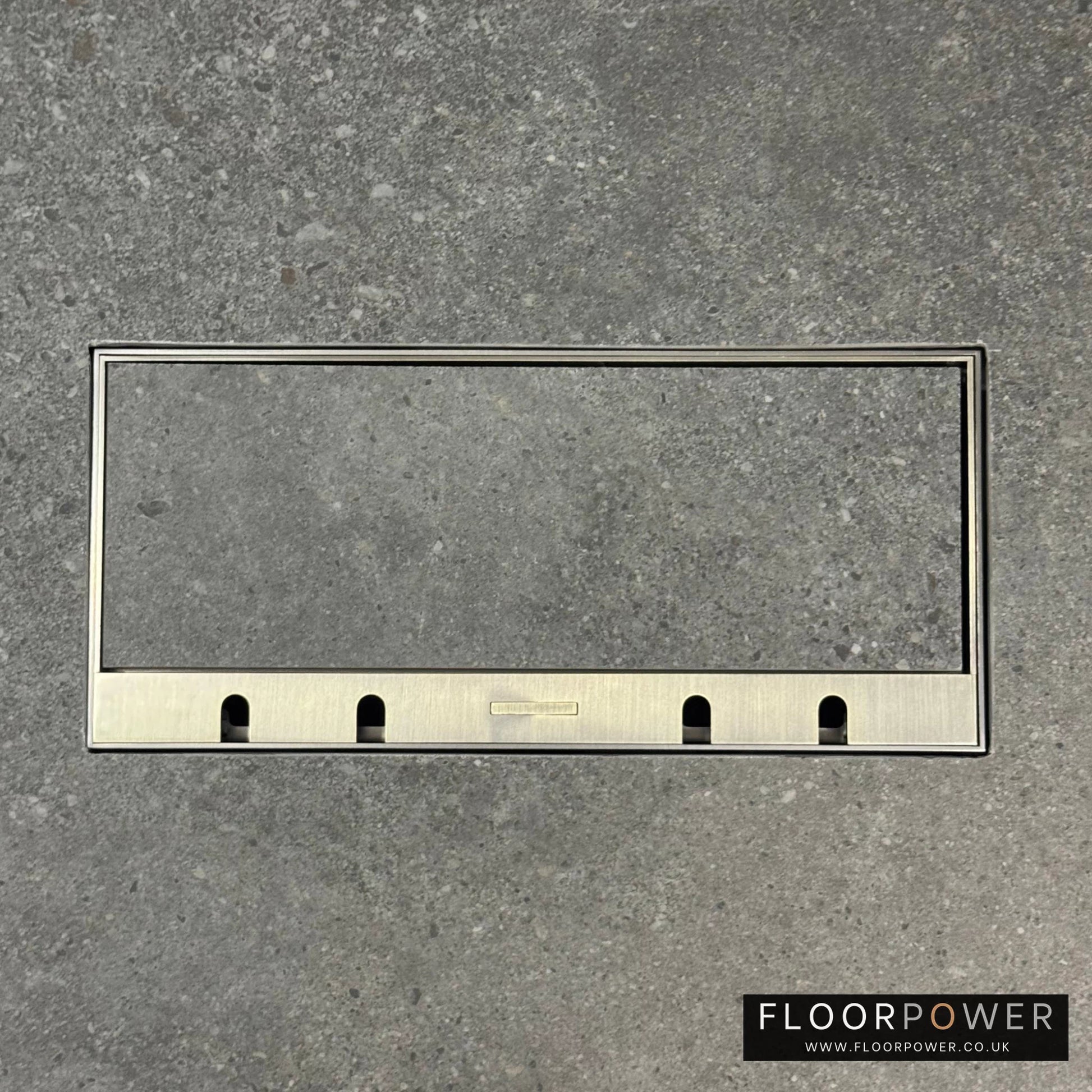 Flush Recessed Floor Socket with Antique Brass Surround in grey stone floor