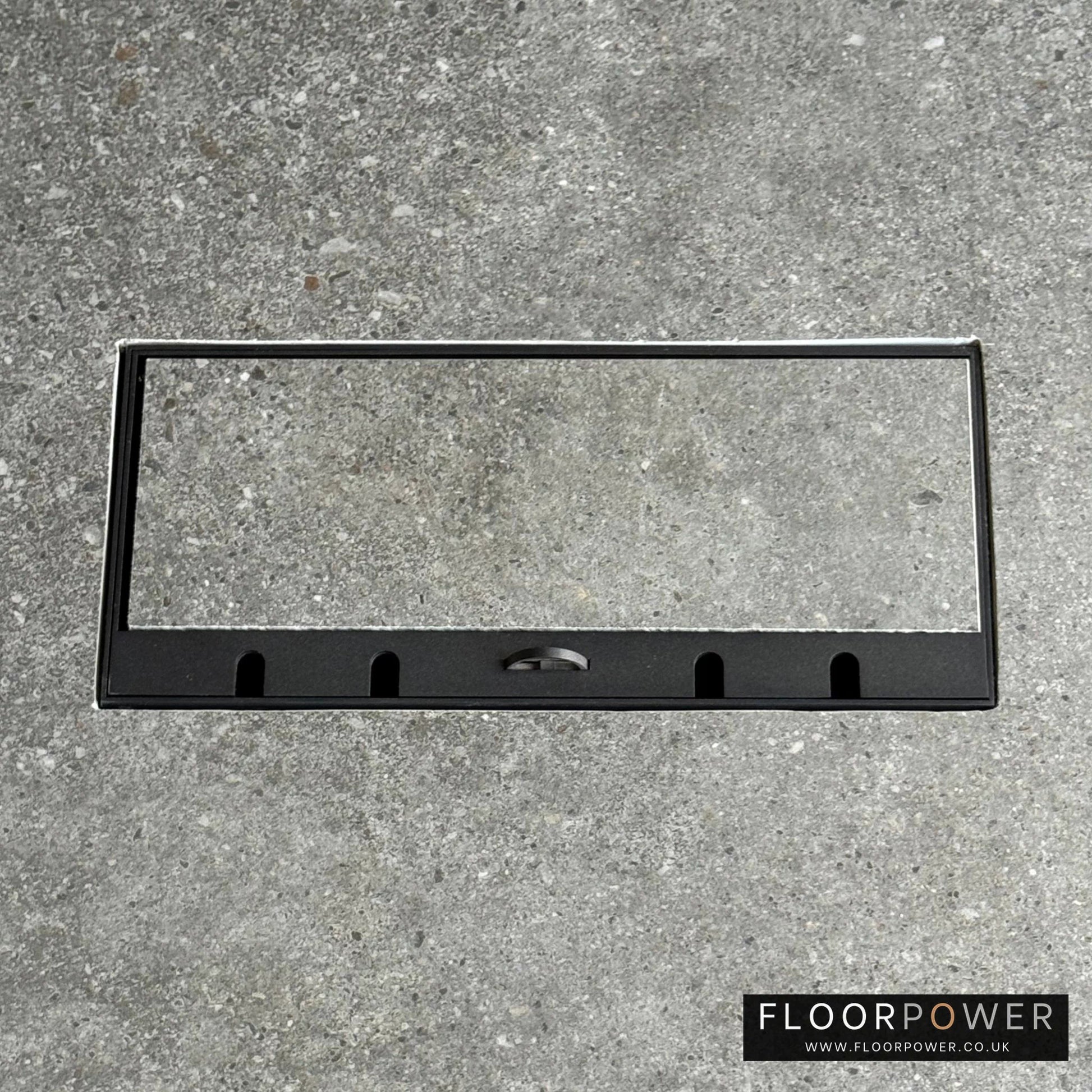 Flush Recessed Floor Socket with Black Surround in grey stone floor showing the lid handle in the up position