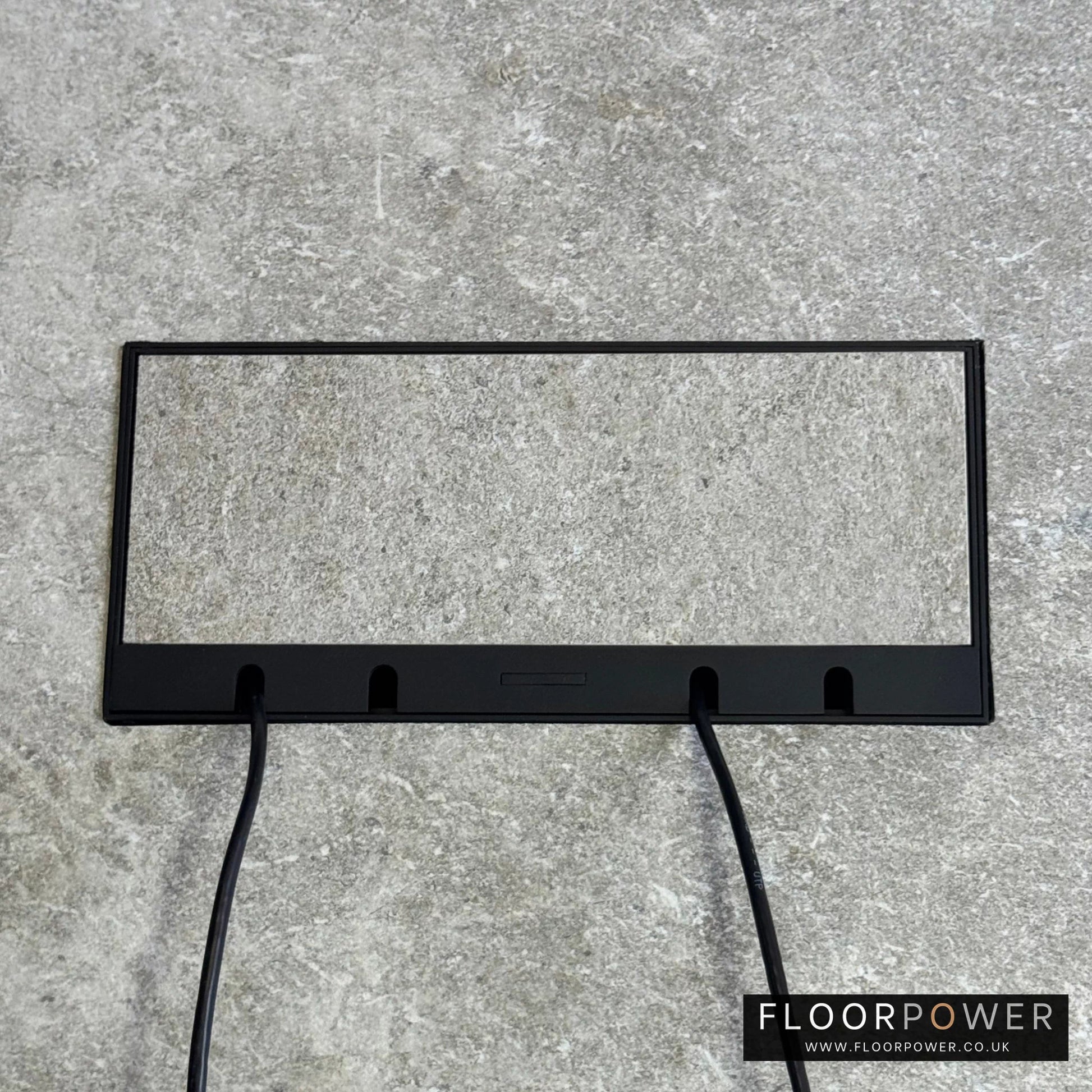 Flush Recessed Floor Socket with Black Surround in light stone floor showing closed lid and 2 wires coming out