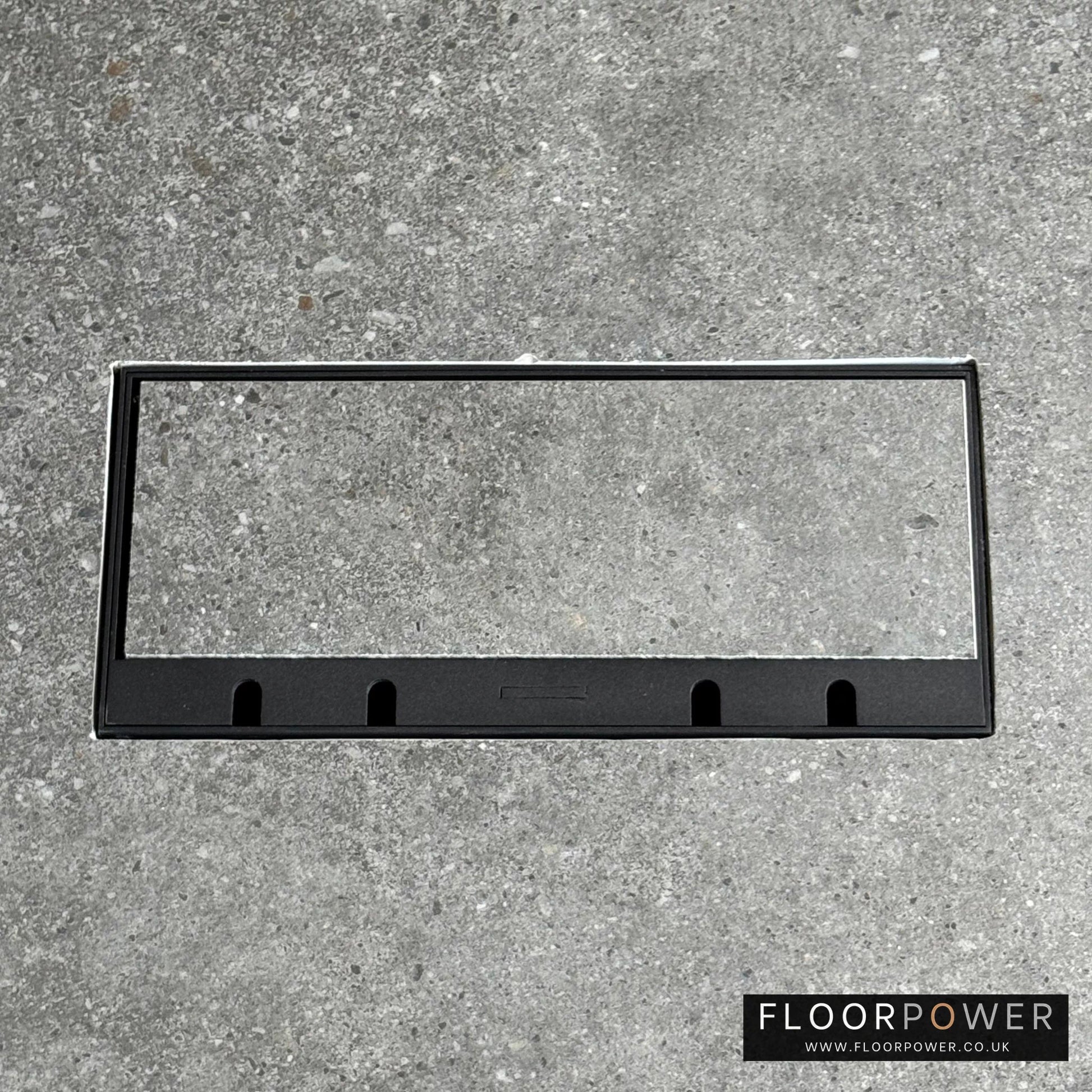 Flush Recessed Floor Socket with Black Surround in grey stone floor