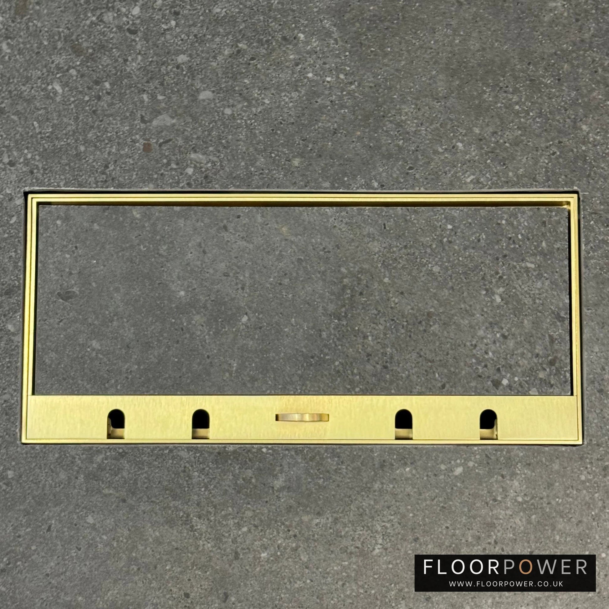 Flush Recessed Floor Socket with Satin Brass Surround in grey stone floor showing the lid handle in the up position