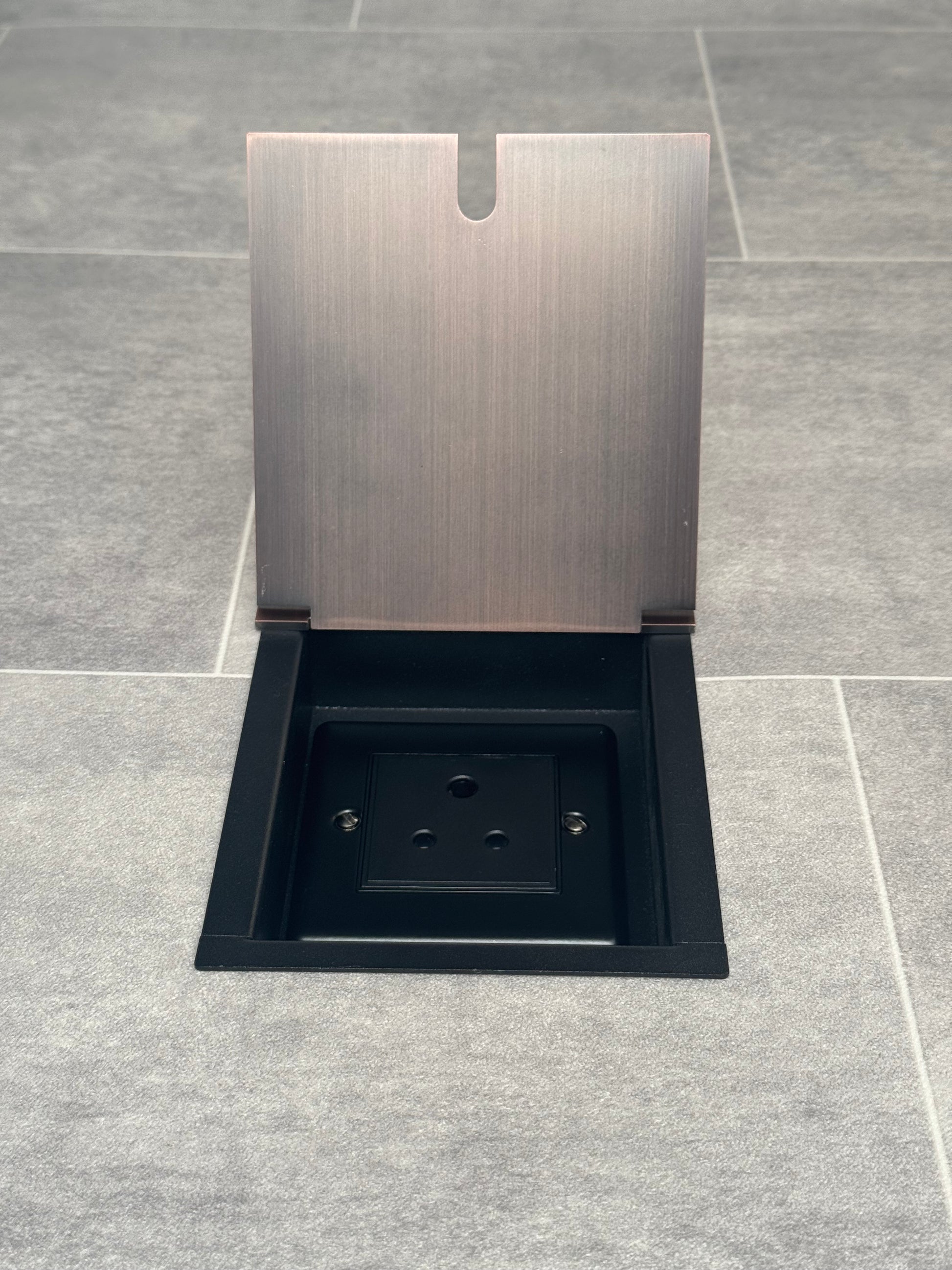 Antique copper recessed floor socket open showing a 5 amp round pin socket (for lighting).