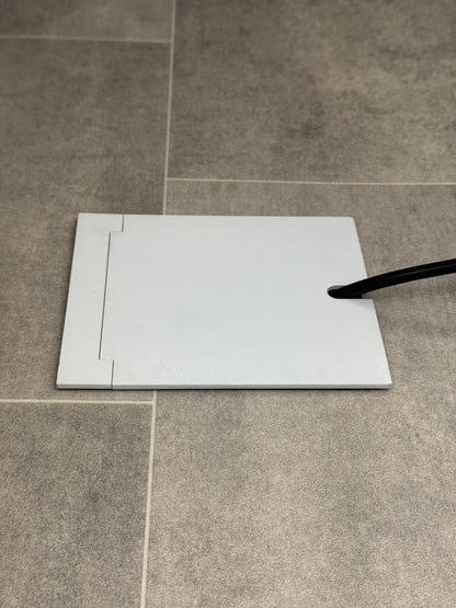 Single Matt White Recessed Floor Socket With Lid Closed Flat Showing Just Cable Coming Out If The Socket - Side On View.
