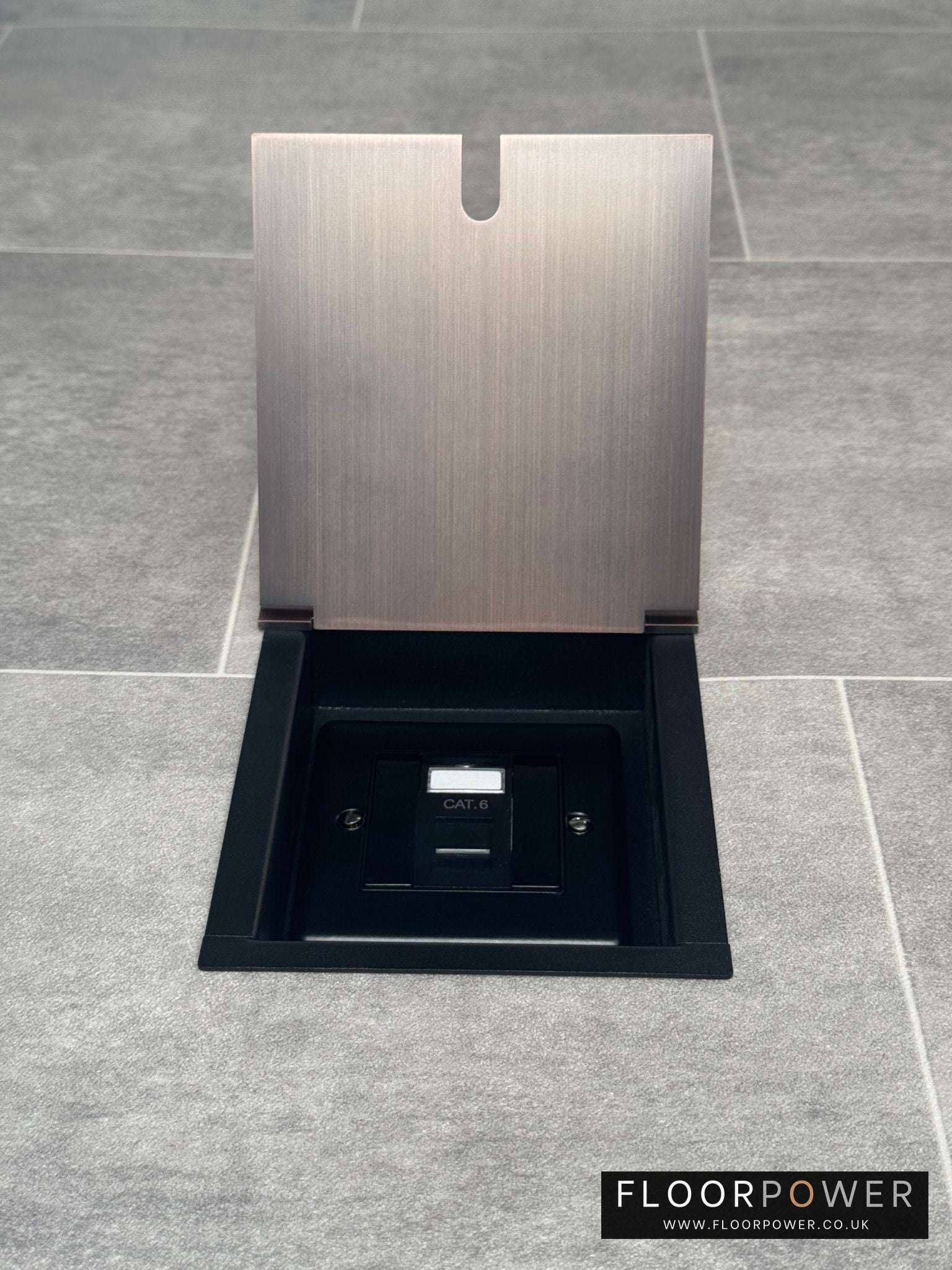 Single Cat6 RJ45 recessed floor socket with a antique copper finish installed in a tiled floor.