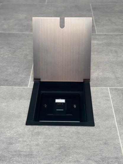 Single Cat6 RJ45 recessed floor socket with a antique copper finish installed in a tiled floor.
