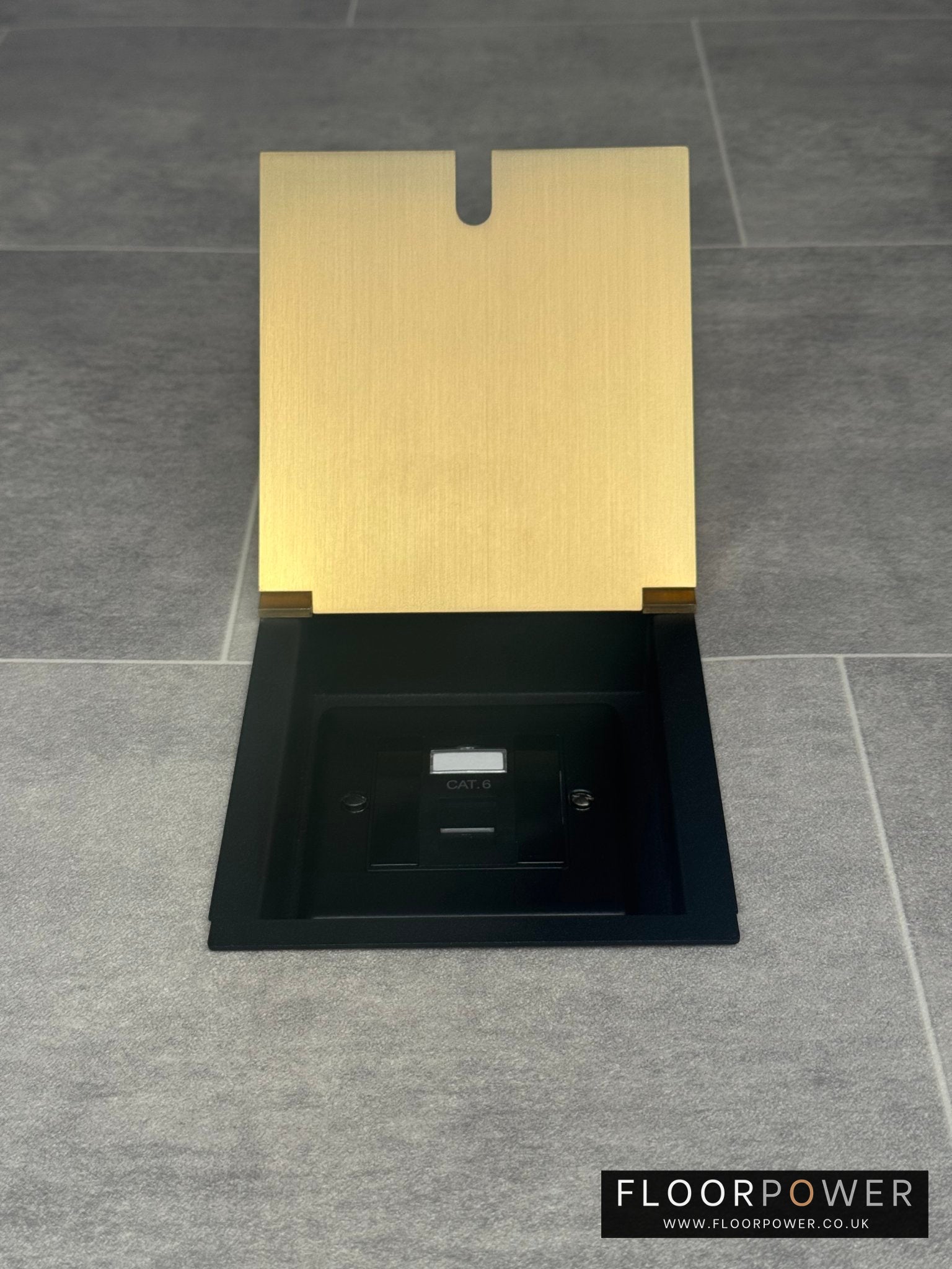 A satin brass recessed floor socket with a black base, opened to reveal the Cat6 RJ45 socket.