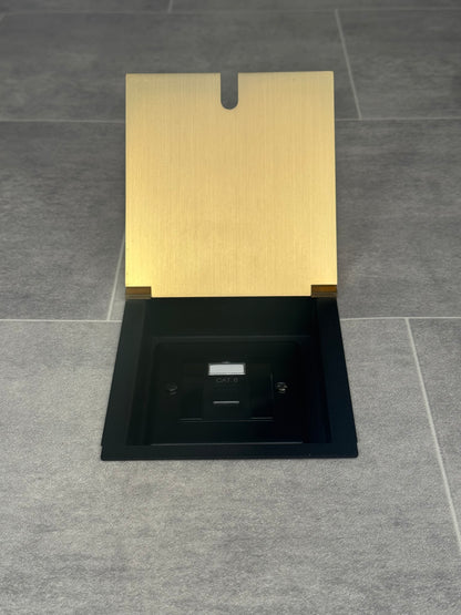 A satin brass recessed floor socket with a black base, opened to reveal the Cat6 RJ45 socket.