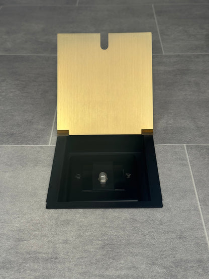 A satin brass recessed floor socket with a single satellite socket, installed on a grey floor.