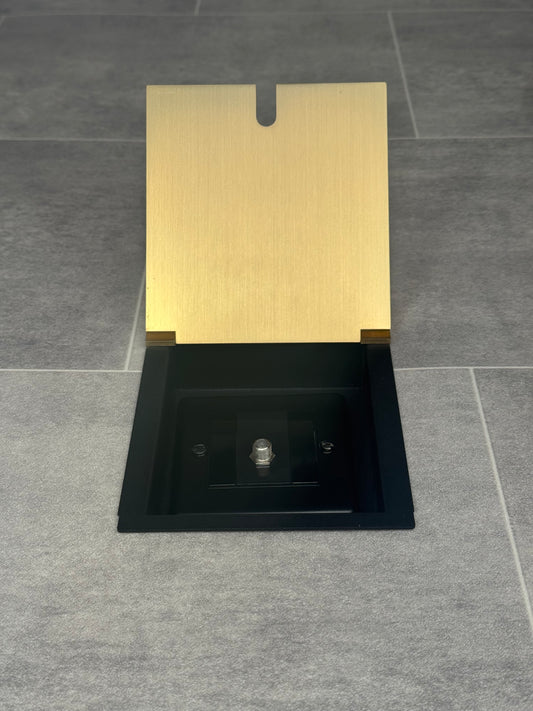 A satin brass recessed floor socket with a single satellite socket, installed on a grey floor.