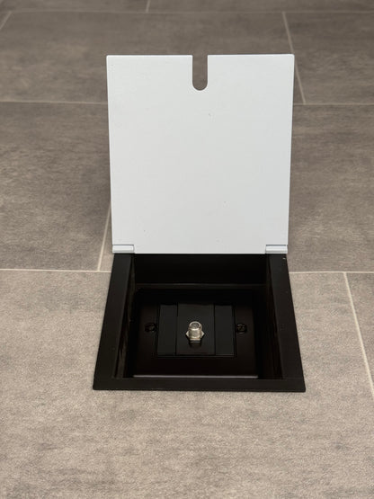 A white recessed floor socket with a single satellite connector.