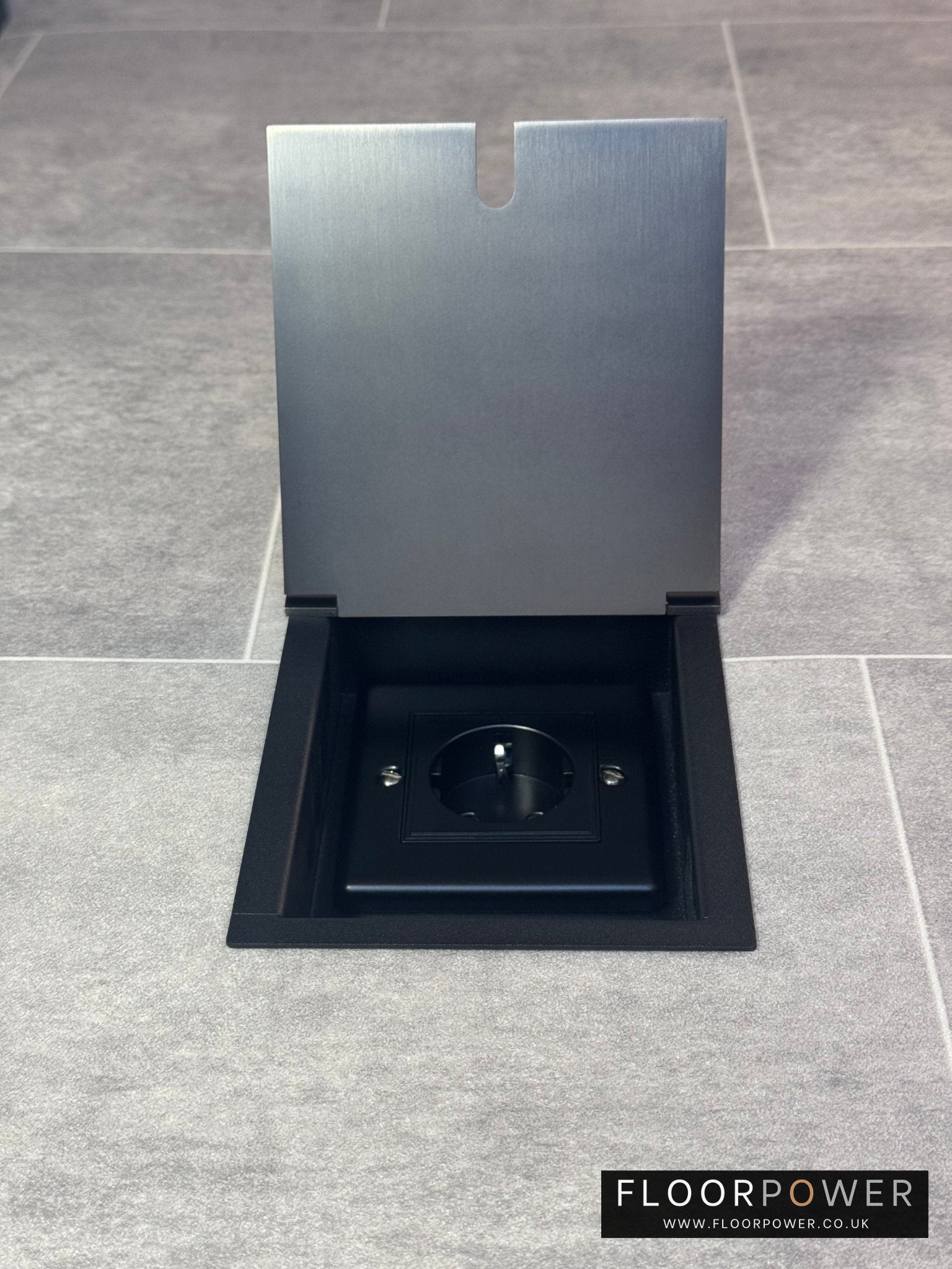 Old bronze recessed floor socket with a single Schuko (European) socket.