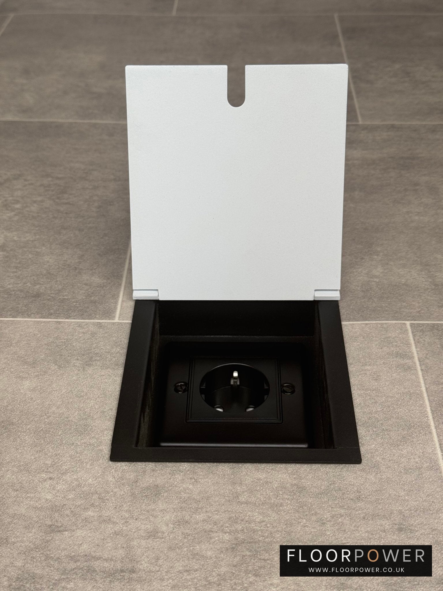 White recessed floor socket with a single Schuko (European) plug socket.