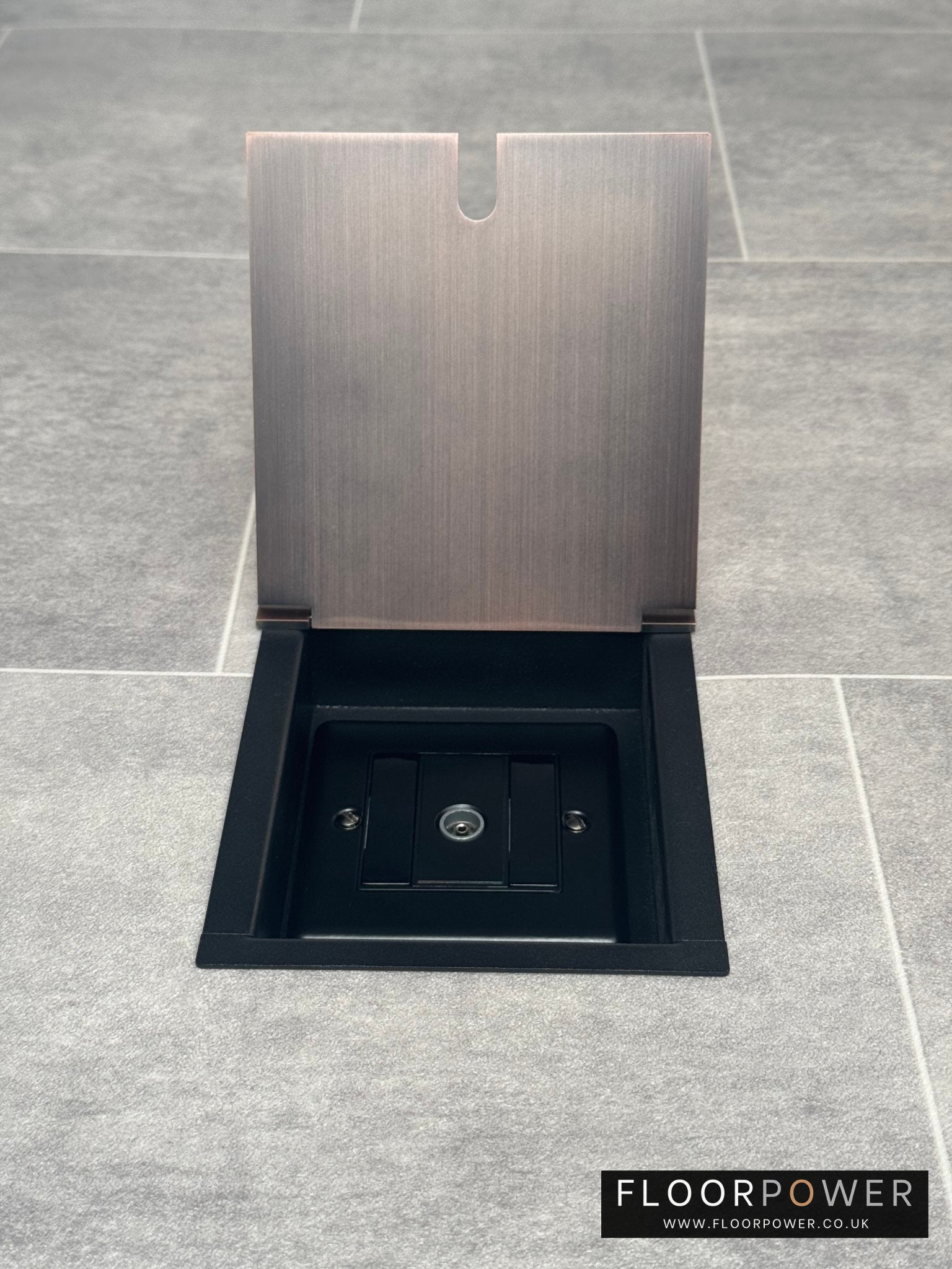 Antique copper recessed floor socket with a single gang TV socket, opened to show the socket.