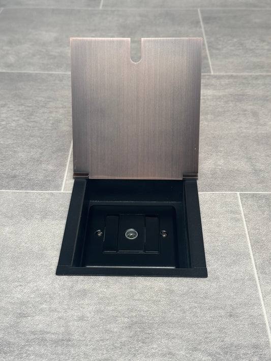 Antique copper recessed floor socket with a single gang TV socket, opened to show the socket.