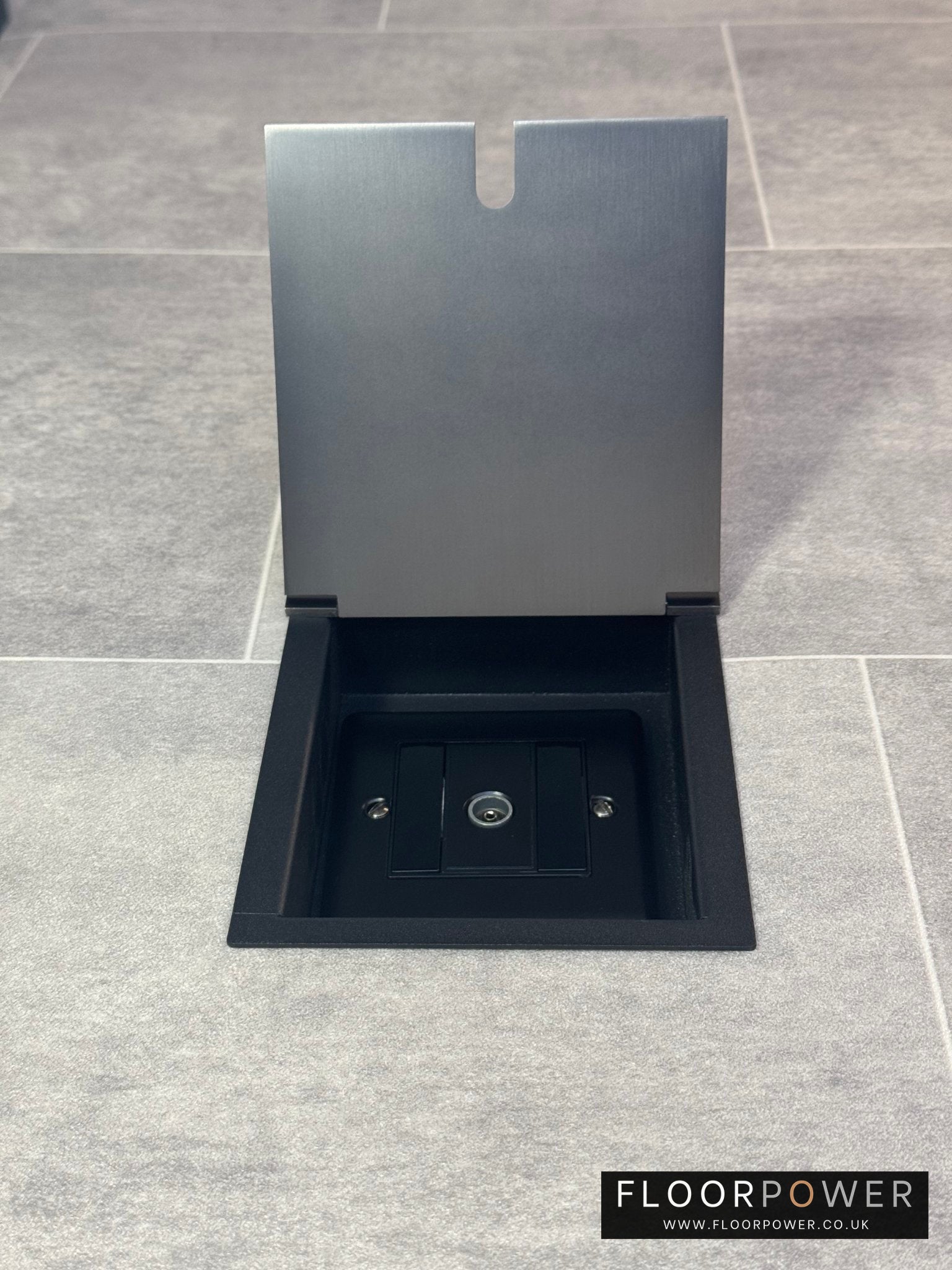 Recessed floor socket in old bronze installed on a tiled floor, featuring a 1 gang TV socket.