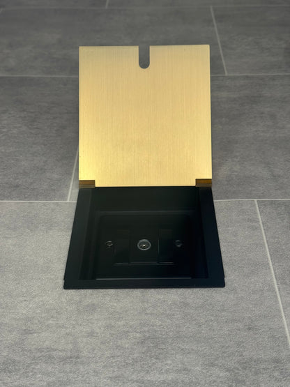 A satin brass recessed floor socket with a single 1 gang TV aerial socket, shown open,  installed in a floor.