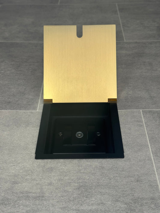 A satin brass recessed floor socket with a single 1 gang TV aerial socket, shown open,  installed in a floor.