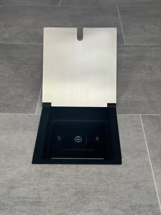 A satin stainless recessed floor socket with a single 1 gang TV aerial socket, shown open,  installed in a floor.