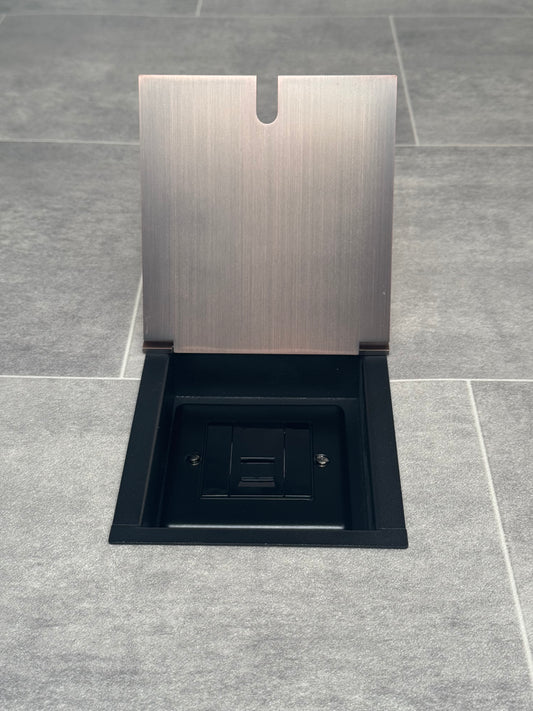 UK phone socket in recessed floor socket with antique copper finish installed in floor tiles.