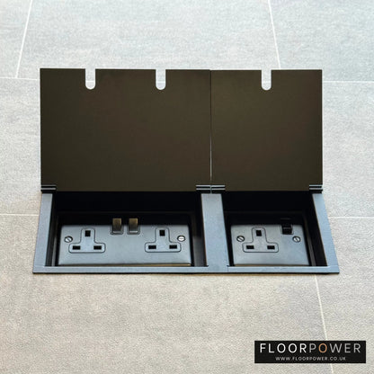 Matt Blackl triple floor plug socket with double 13A switched plug socket and a single 13A switched plug socket, both lids open.