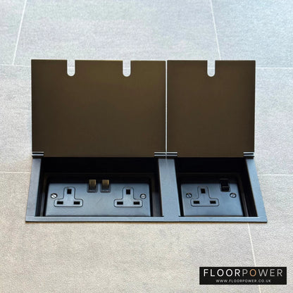 Old Bronze triple floor plug socket with double 13A switched plug socket and a single 13A switched plug socket, both lids open.