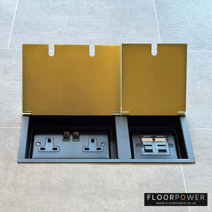 Satin Brass network combination triple floor socket with double 13A switched plug socket and two RJ45 Cat6 network socket, both lids open.