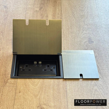 Triple Recessed Floor Socket in Antique Brass on a wood floor, with double side lid open showing plug socket.