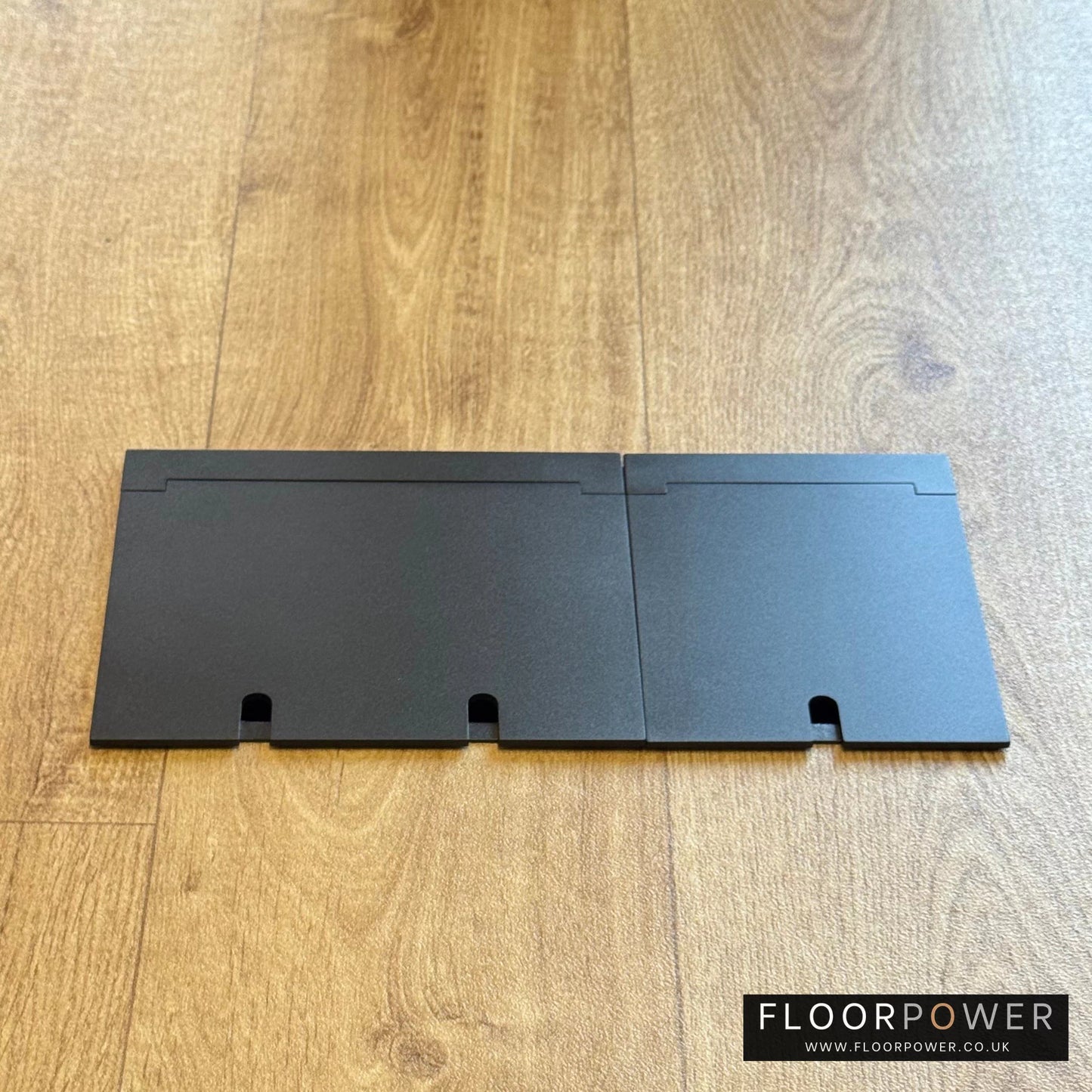 Closed Triple Recessed Floor Socket in Matt Black on wood floor.