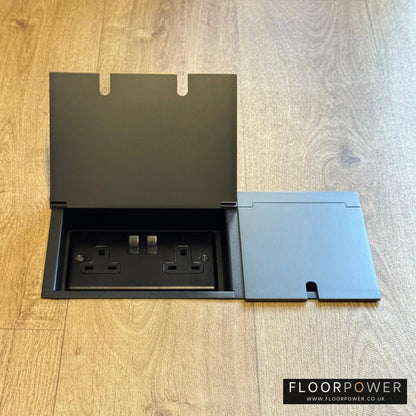 Triple Recessed Floor Socket in Old Bronze on a wood floor, with the double side lid open showing plug socket.