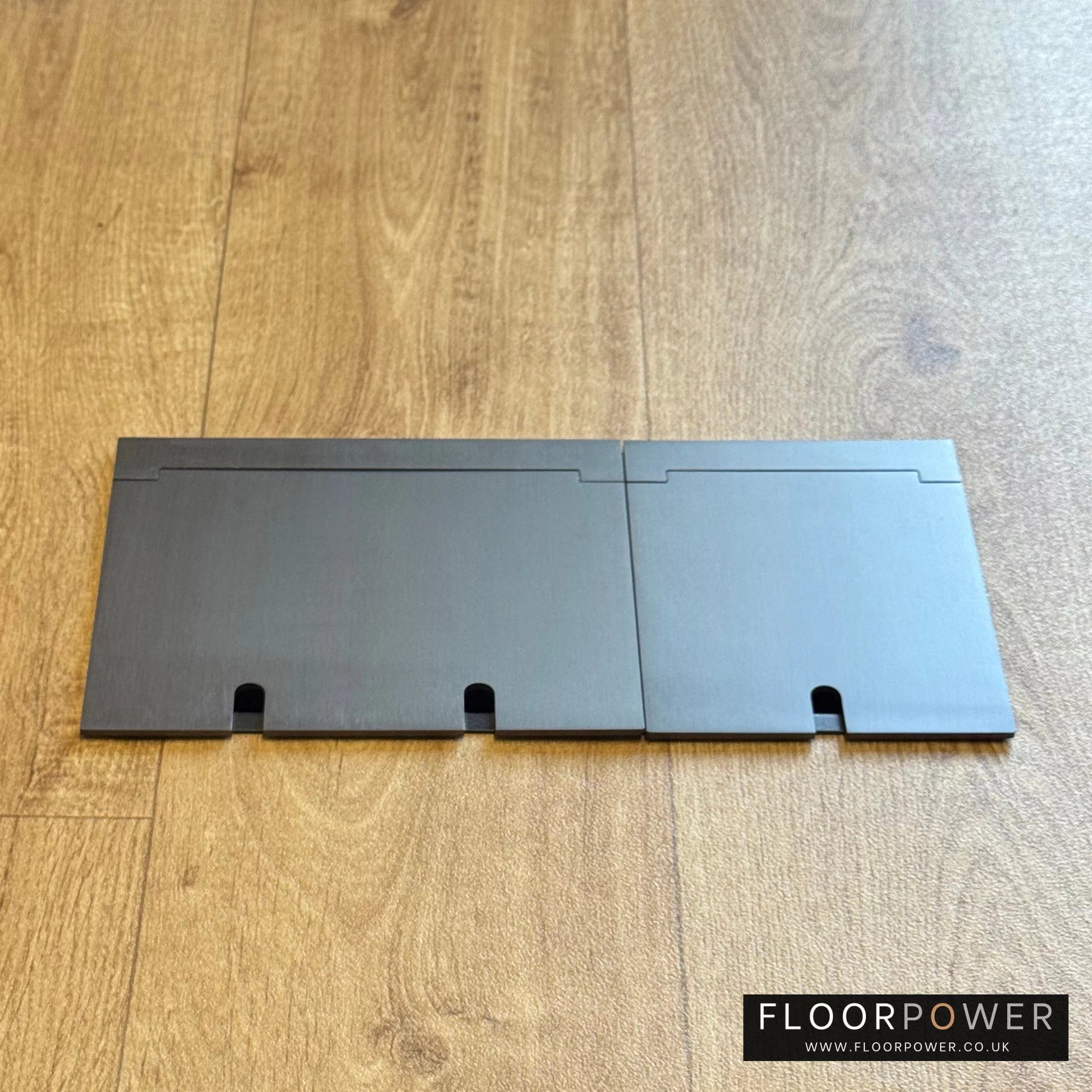 Closed Triple Recessed Floor Socket in Old Bronze on wood floor.