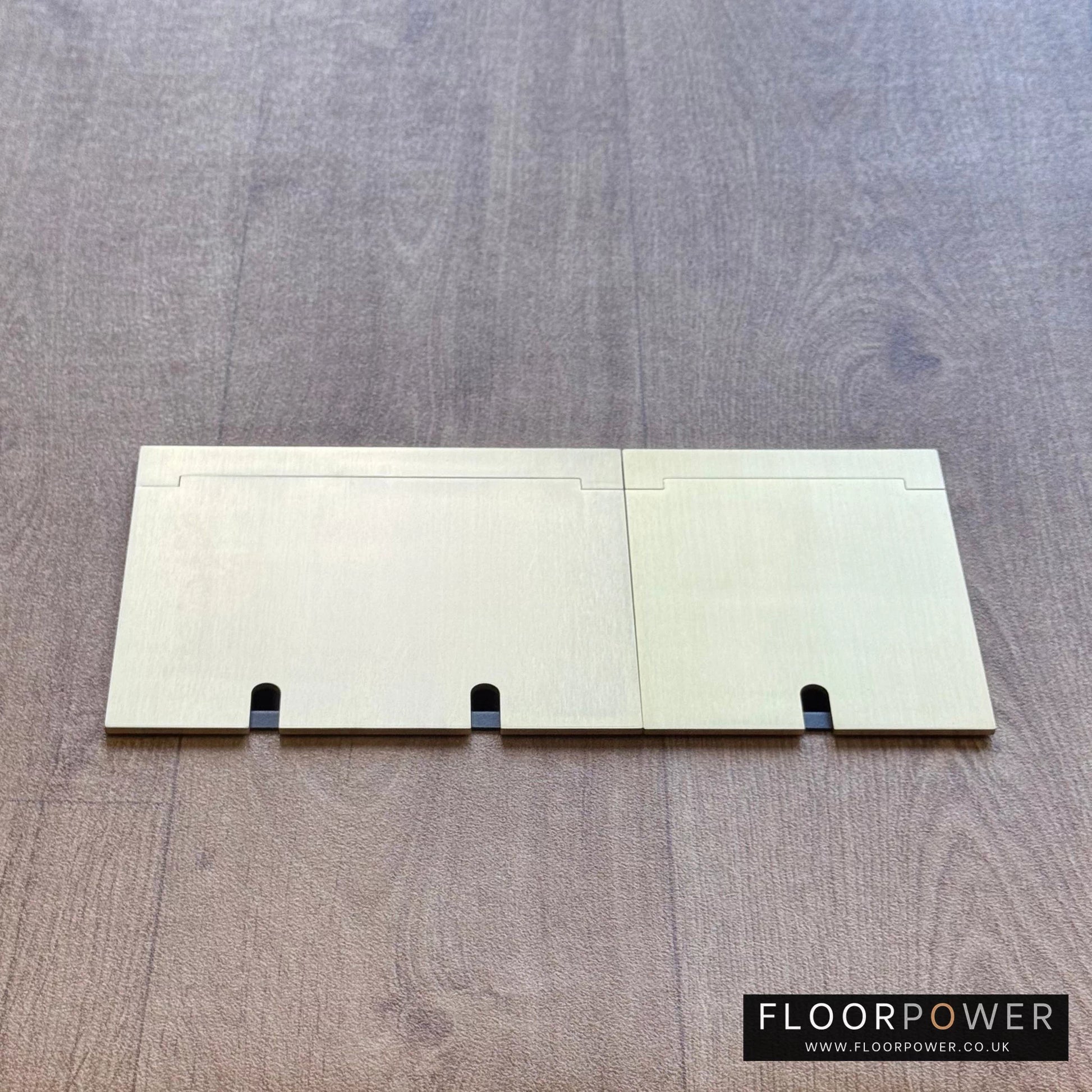 Closed Triple Recessed Floor Socket in Satin Brass on wood floor.
