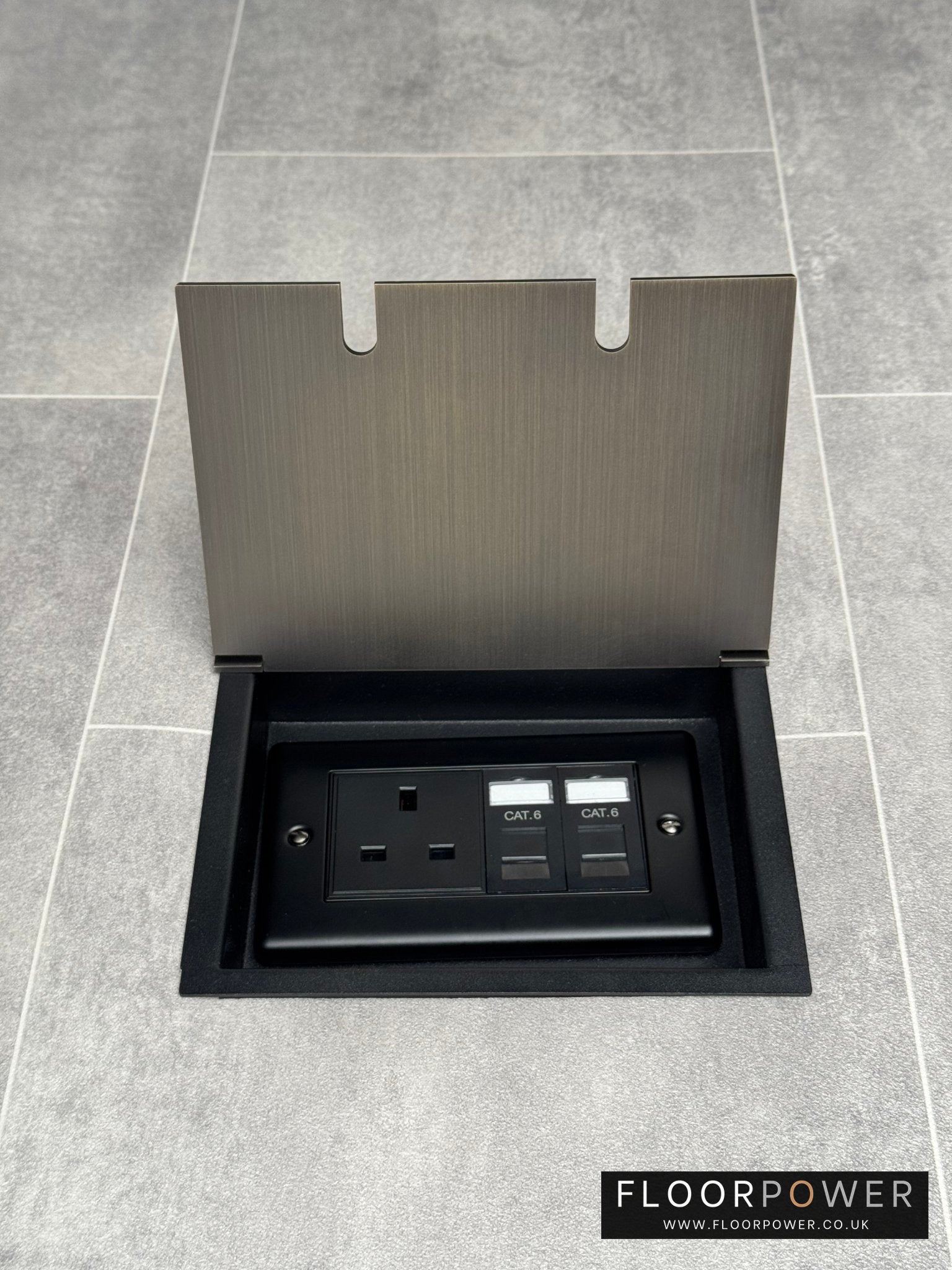 Recessed floor socket in antique brass with a double box containing one 13amp unswitched socket and two RJ45 sockets, set in a tiled floor setting.