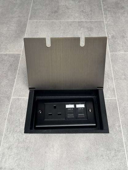 Recessed floor socket in antique brass with a double box containing one 13amp unswitched socket and two RJ45 sockets, set in a tiled floor setting.